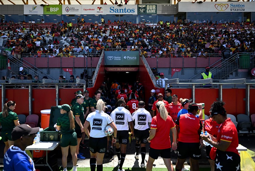 PNG Orchids captain Elsie Albert carries water for her side as teams enter the sheds during the Prime Minister's XIII match in Port Moresby. 