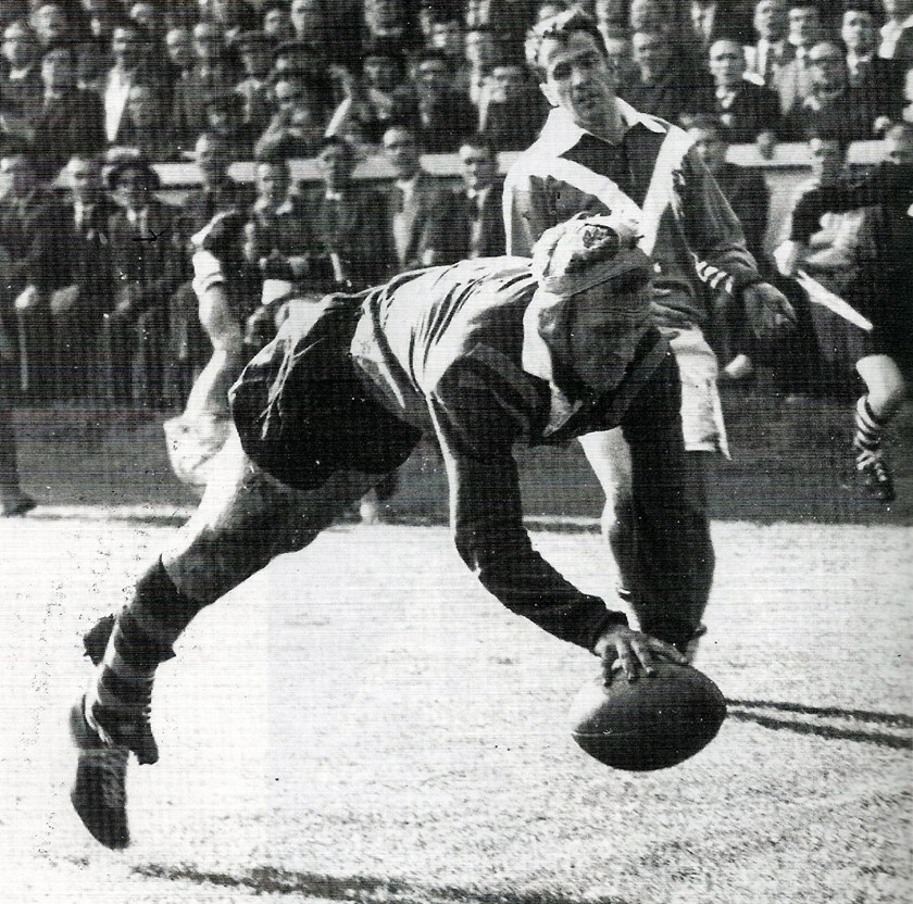 Raper, wearing headgear, dives over for a try against France.